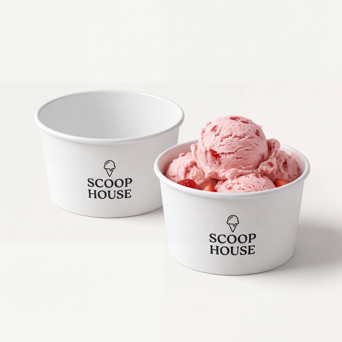 Short white paper dessert cups with a sample black ice cream logo, one filled with strawberry ice cream.